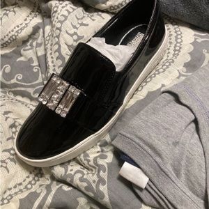 Micheal Kors slip on black patent leather sneaker.